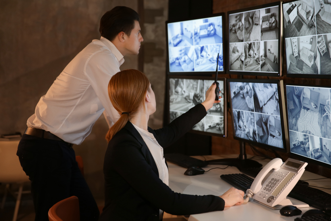 Two Security Guards Working in Surveillance Room